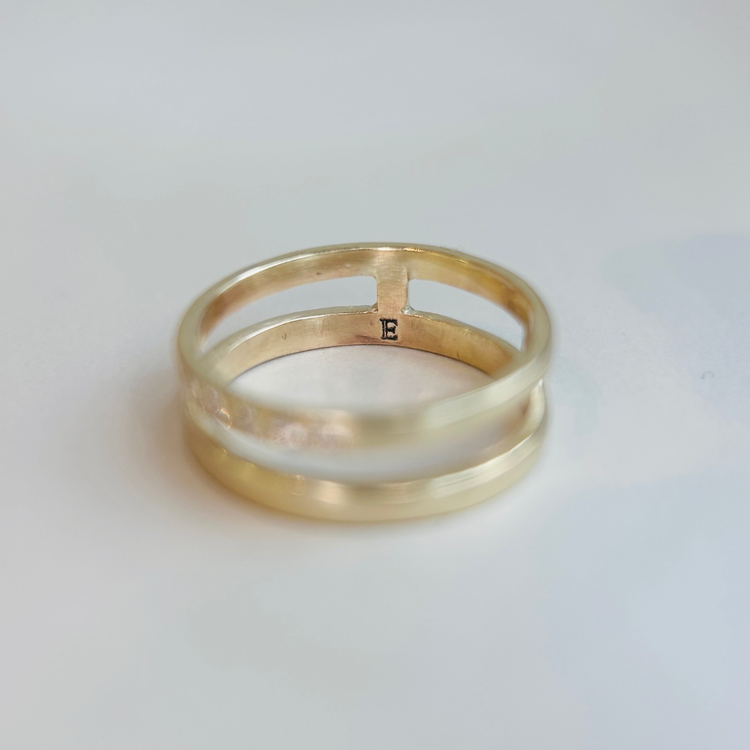 Gold ring with a plain design on a light gray background