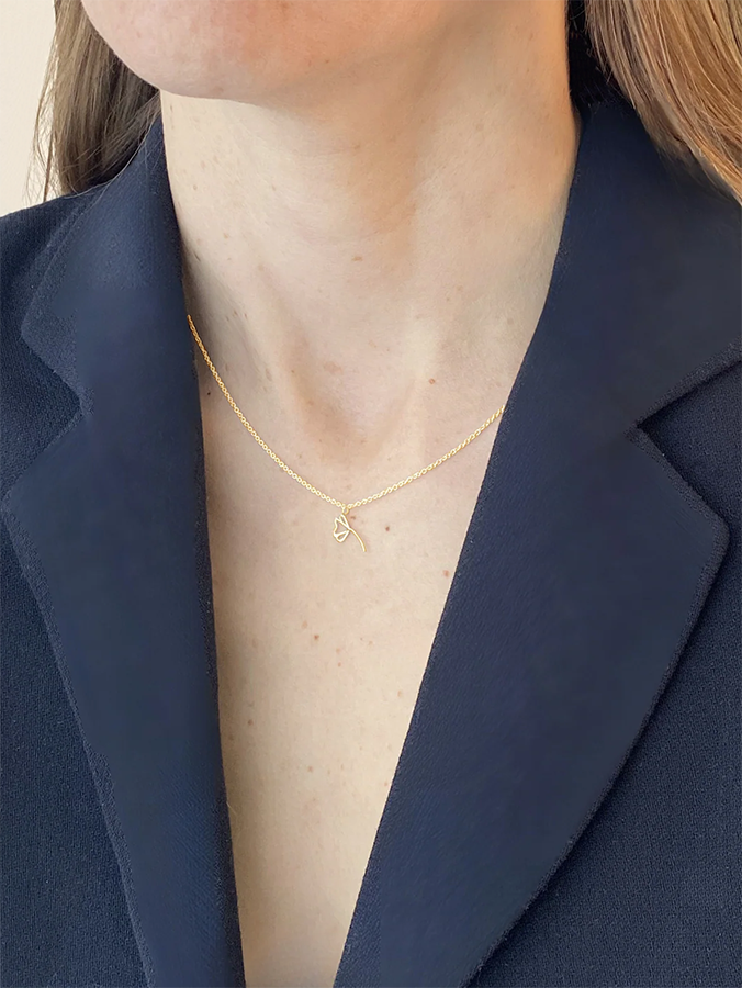 Person wearing a gold necklace with a blue blazer