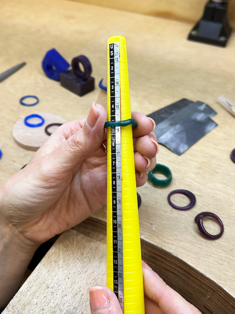 Mesure d’une bague en cire sur un triboulet de bijoutier lors de la conception d’une bague sur mesure, atelier de fabrication de bijoux à Montréal par Camillette.